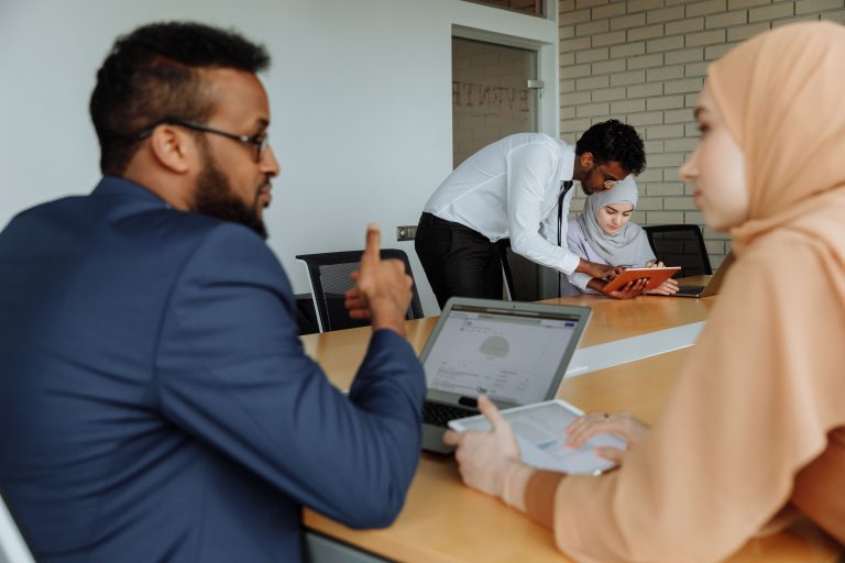 professional staff collaborating around a computer screen with data visualizations