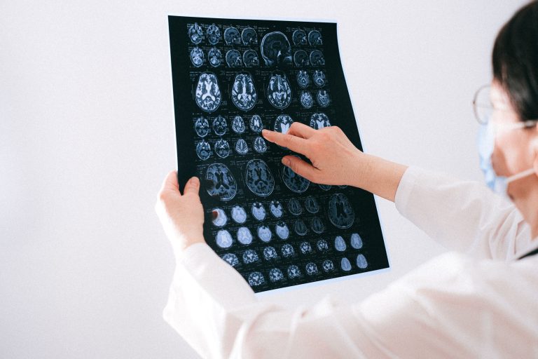 Doctor examines brain MRI scans closely for medical diagnosis in a hospital environment
