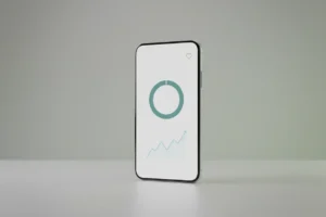 Minimalist smartphone with clean charts on a soft green background, symbolizing calm budgeting for better mental well-being.