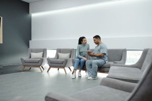 A healthcare professional discusses a tablet with a patient in a clinic