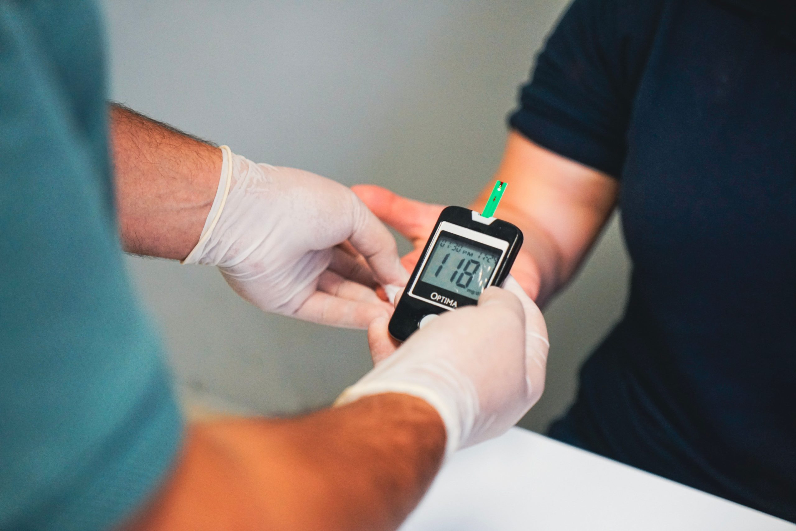 Healthcare professional using glucometer to check blood sugar level, indicating diabetes management